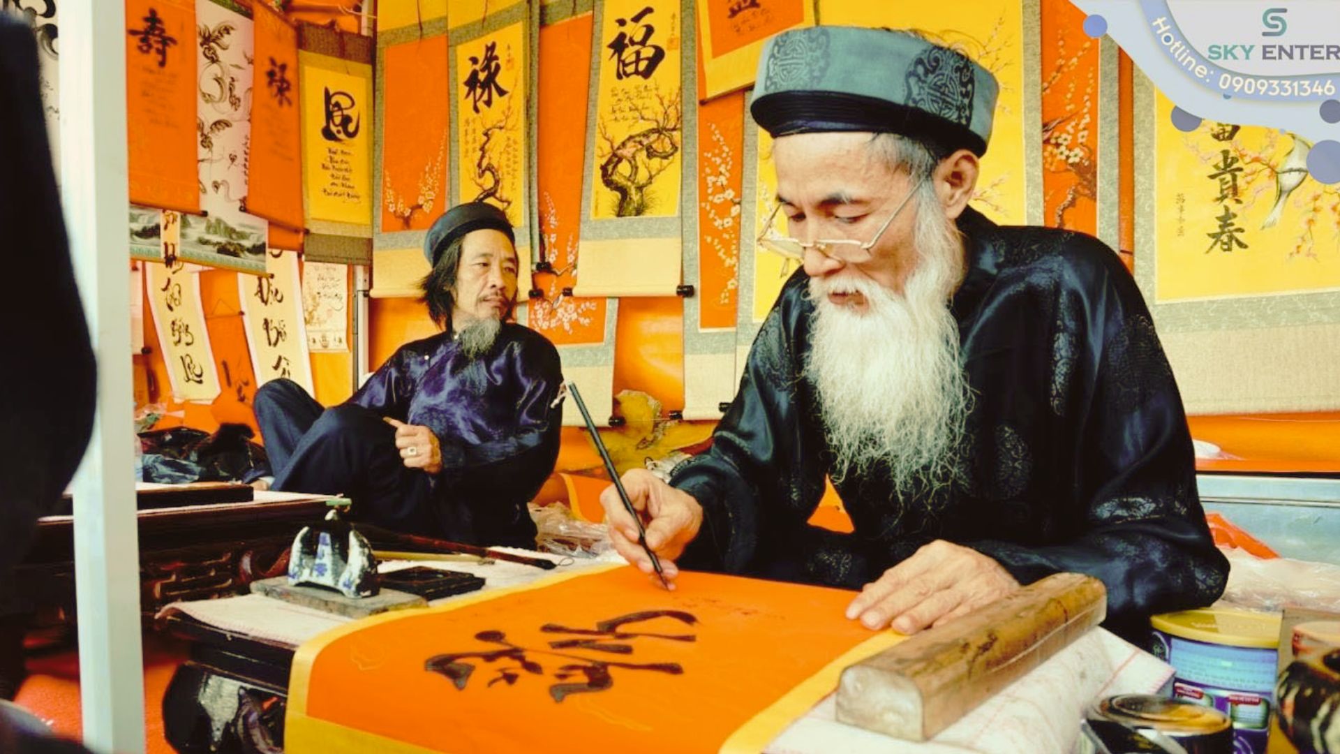 A calligraphy master in an ao dai writes calligraphy with a brush